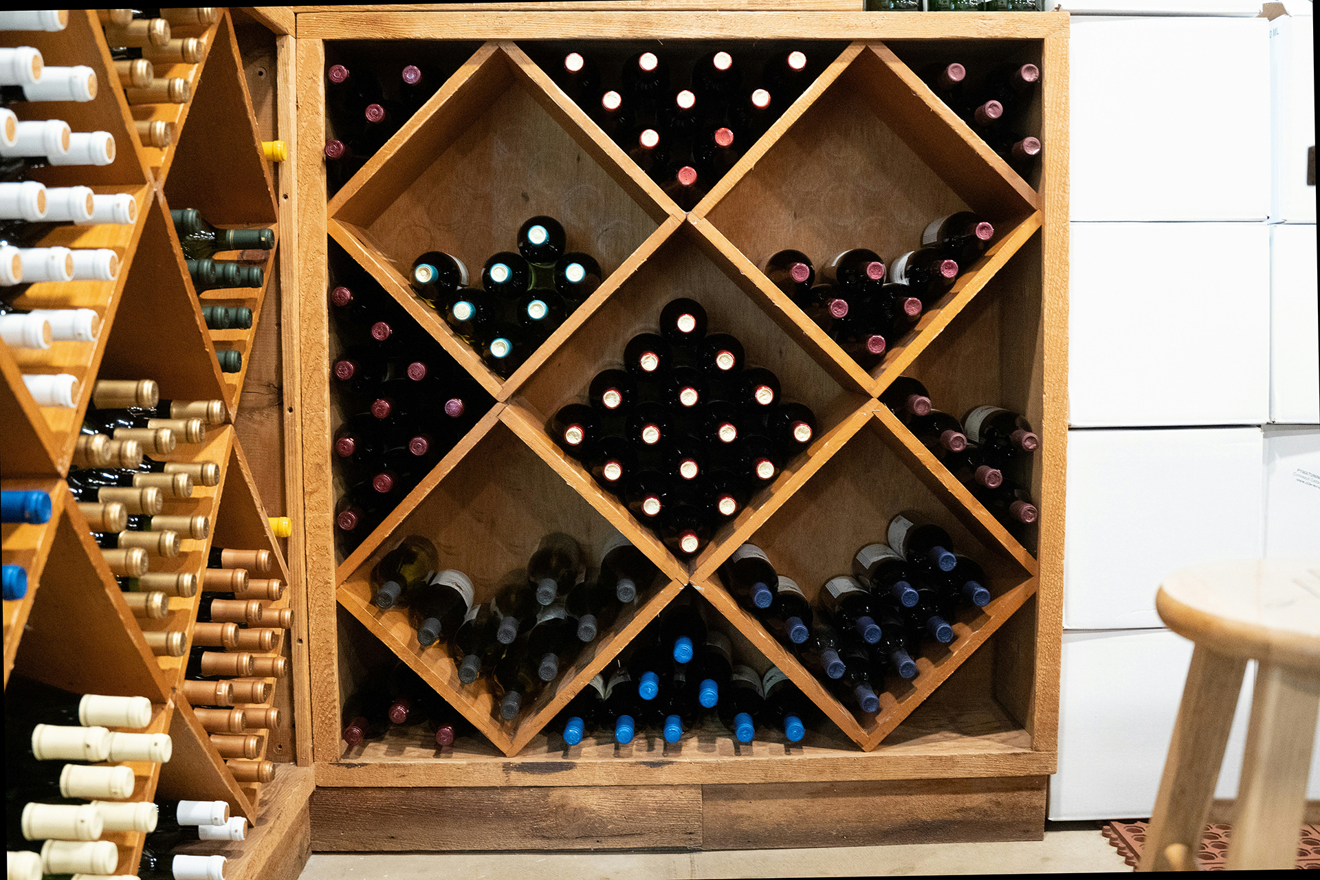 megs-harrison-Pfnu9qCdVec-unsplash Photo of a table holding two wood boxes containing wine bottols and a mason jar candle between them take by Laura Adai