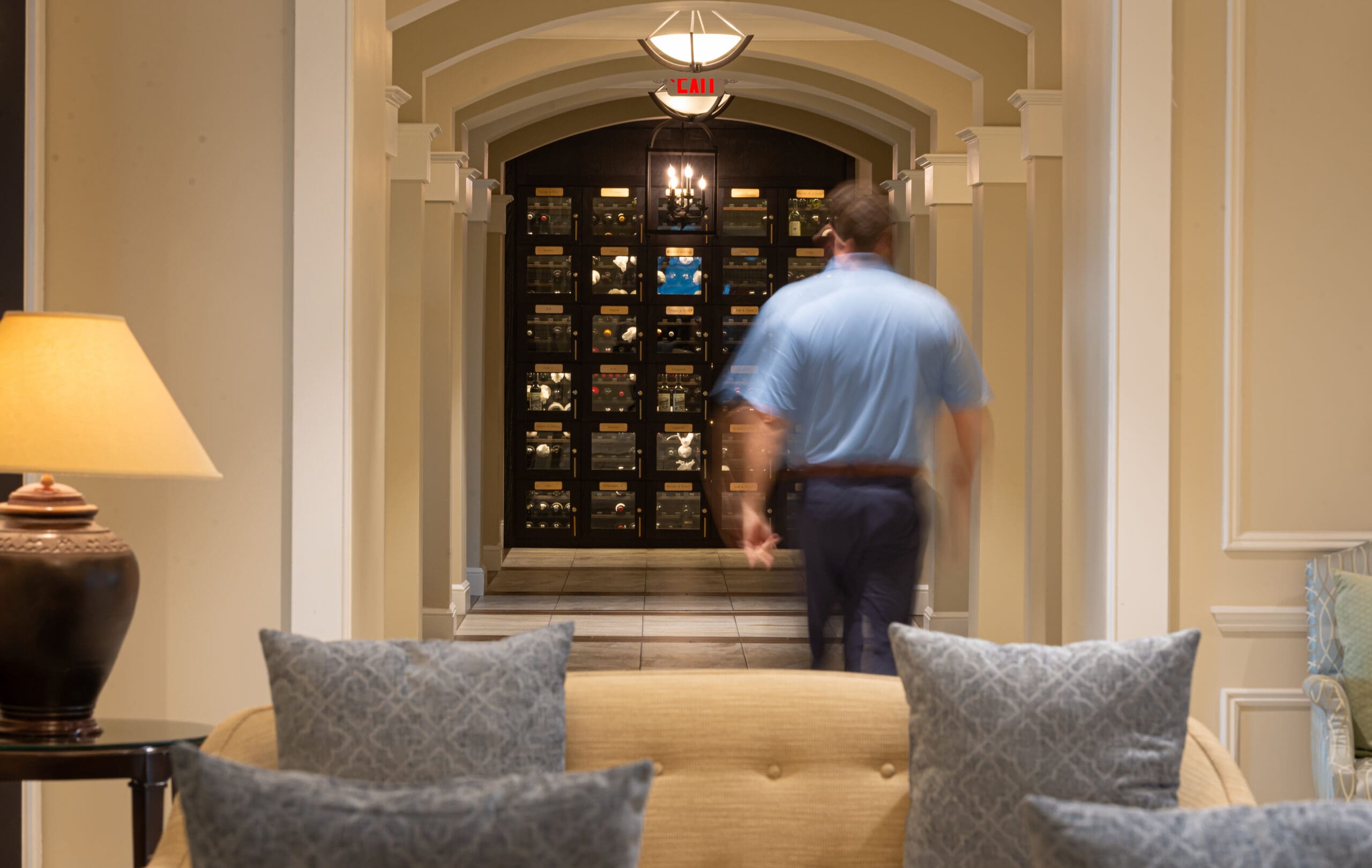 Club member in blue shirt walking to wine lockers