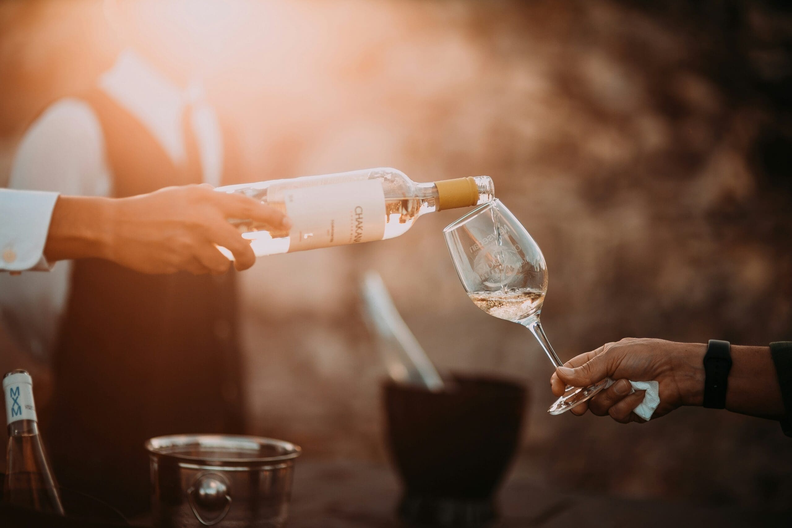 Photo of a waiter filling a member's glass with white wine