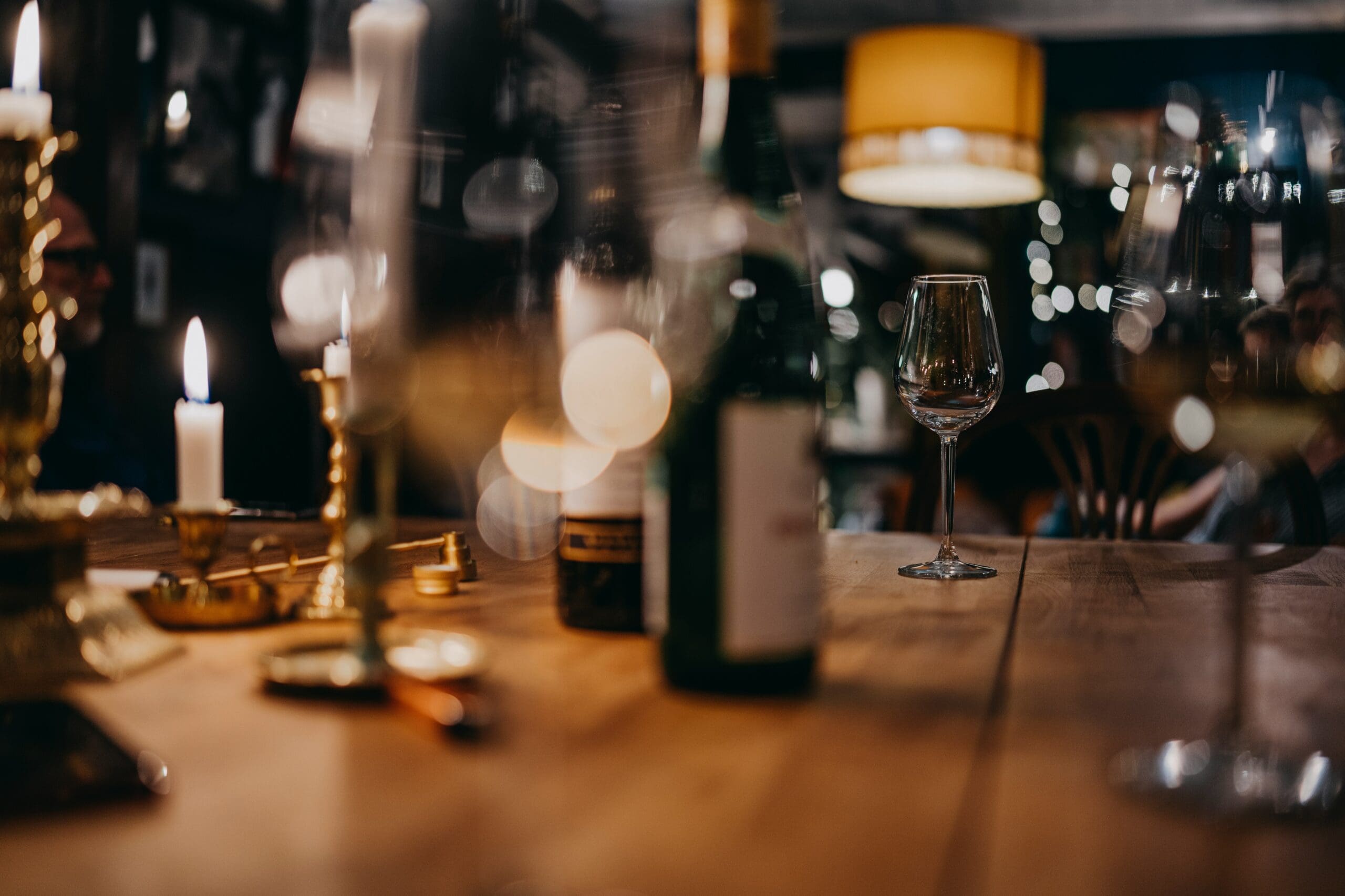 Candlelit table set with wine bottles and glasses for a private club wine dinner