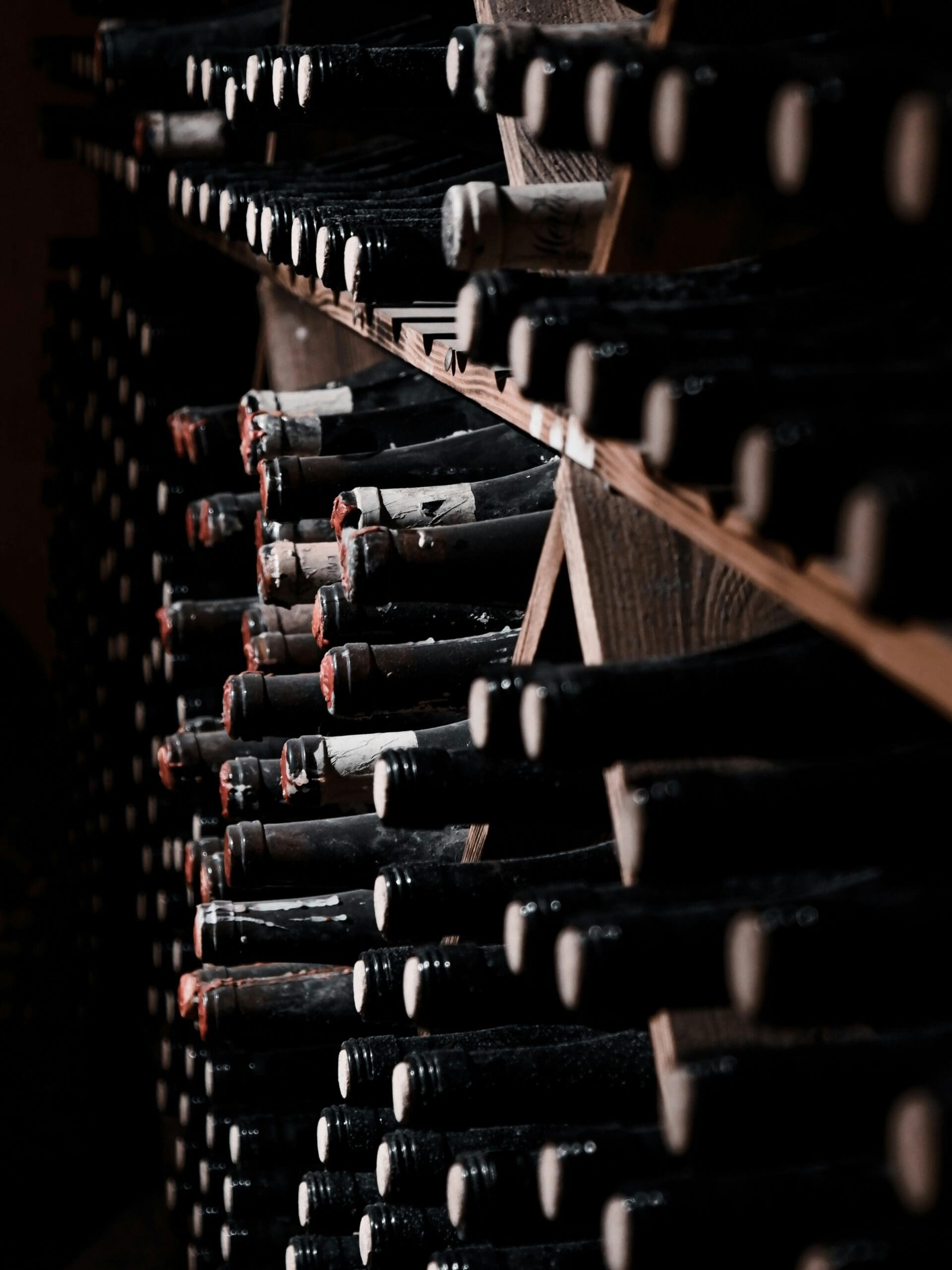 wine-locker-program-bottle-rack Wine bottles resting in a wooden rack, ready to be logged in a private club wine locker program